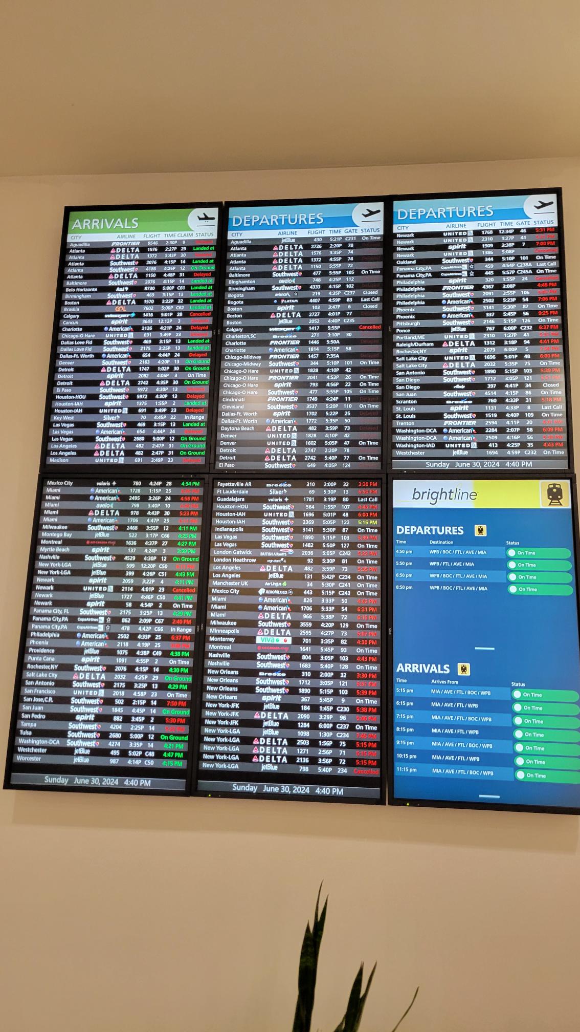 Airport arrivals and departures boards mounted along a shared passage